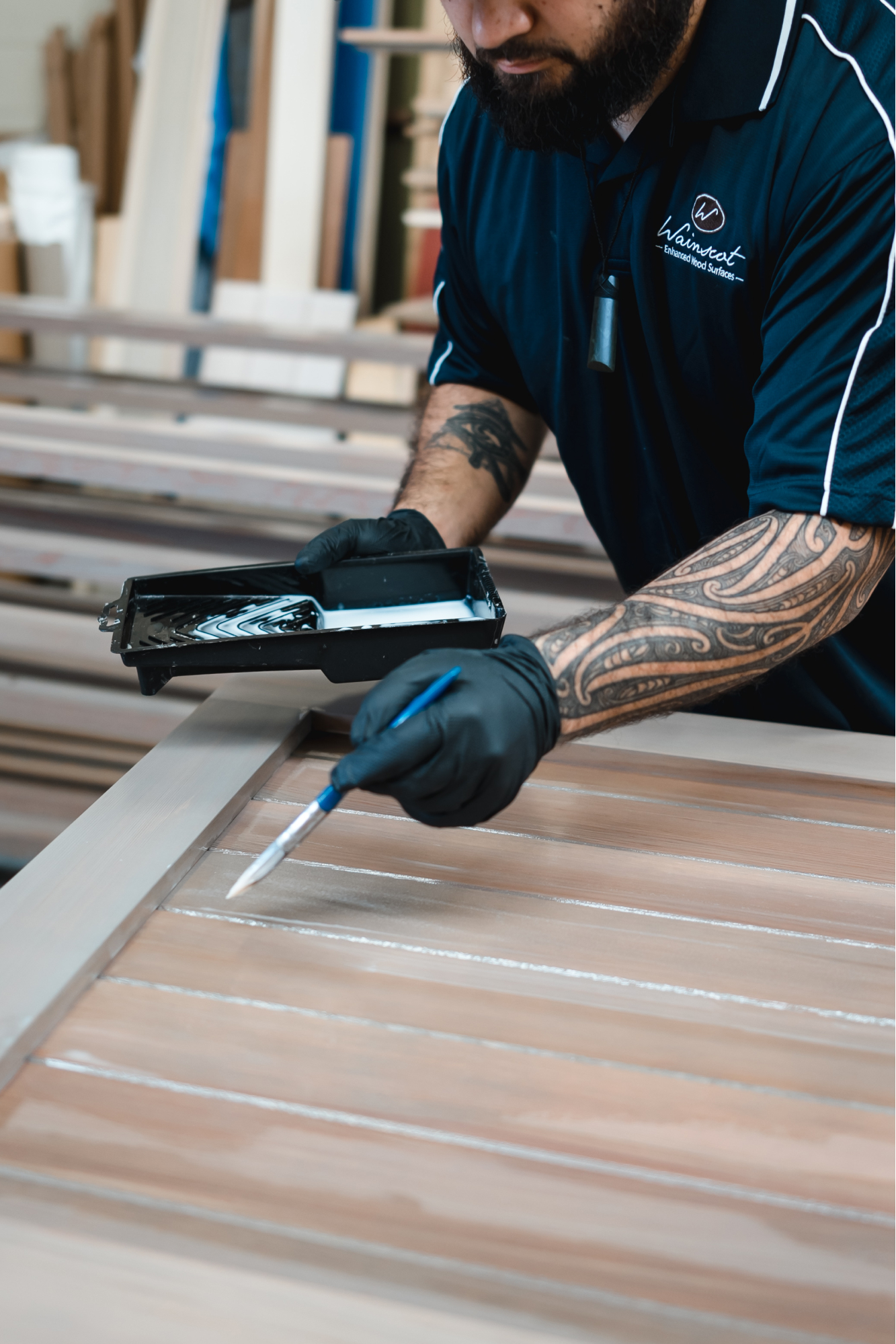 Shayne painting the gaps between planks in a wooden door